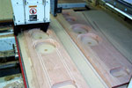 Baffles of Curly Cherry with Rock Maple stringers are cut on the router 