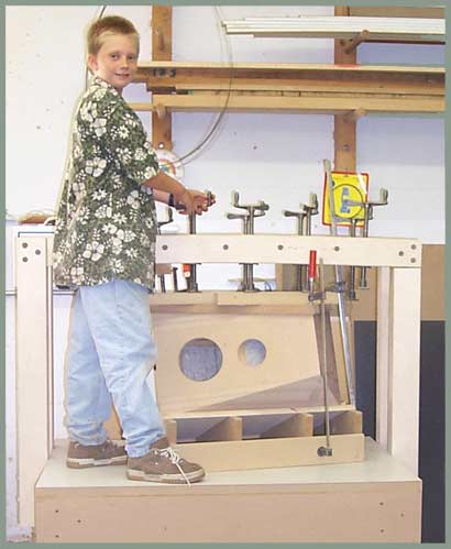 Beau loosens the clamps from the veneer press.